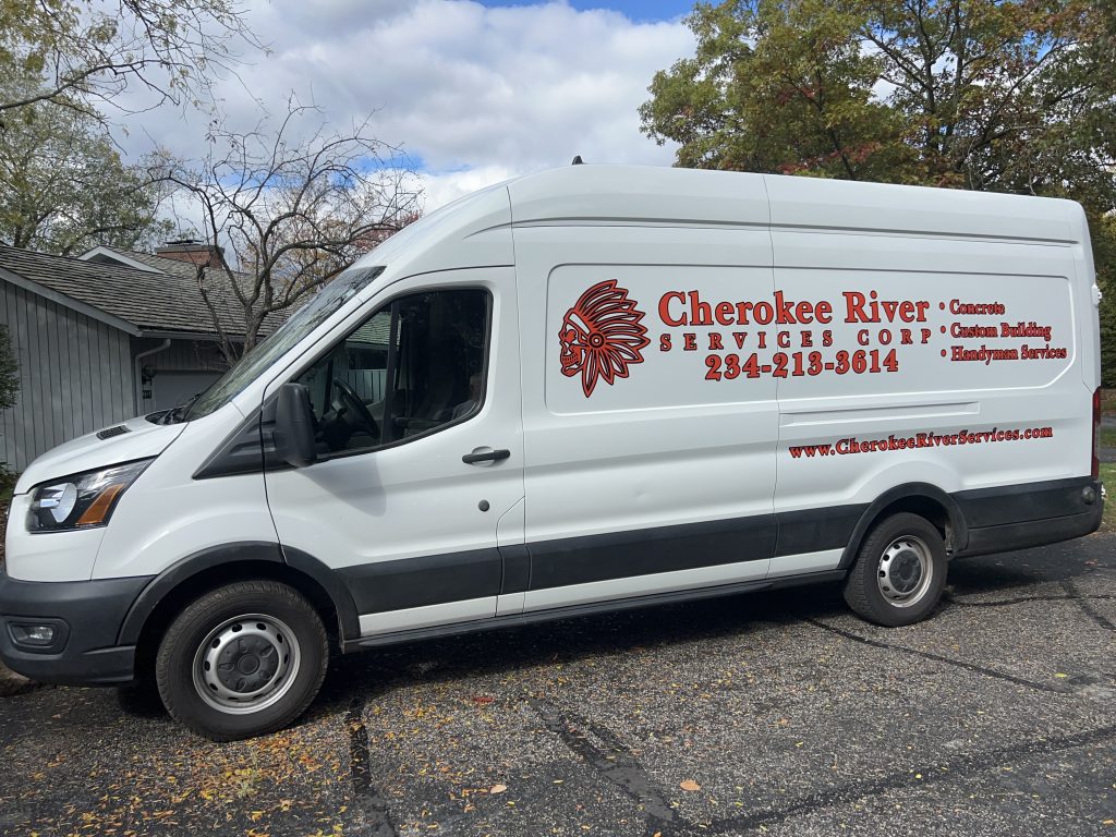 Cherokee River van promotes concrete, building, outdoor living, and handyman services with company info easy to see.